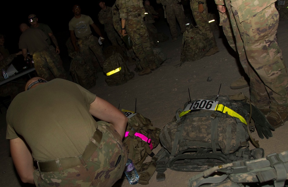 U.S. Army Spc. Peter Trey, Task Force Hellhound, makes adjustments to ruck sack before 12-Mile Ruck March of TF Spartan Best Warrior Competition