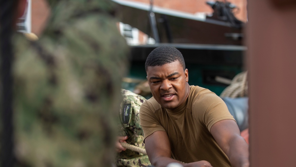 Airman Jabari Shabazz, from Atlanta Georgia, hauls lines to assist the rest of the crew with furling ‘Old Ironsides’ spanker sail