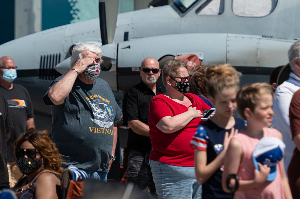 A military veteran salutes during the national anthem