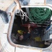 Sailors pass a rat guard through a hatch on the forecastle