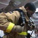 Operations Specialist Seaman Shemar Dyett, from Waytross, Ga., dons a self-contained breathing apparatus during a firefighting drill