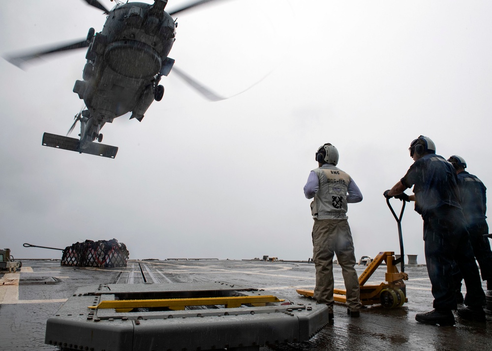 Sailors aboard USS Rafael Peralta (DDG 115) prepare to unload stores from a MH-60R Seahawk assigned to (HSM-51) during a vertical replenishment with USNS Pecos (T-AO-197)