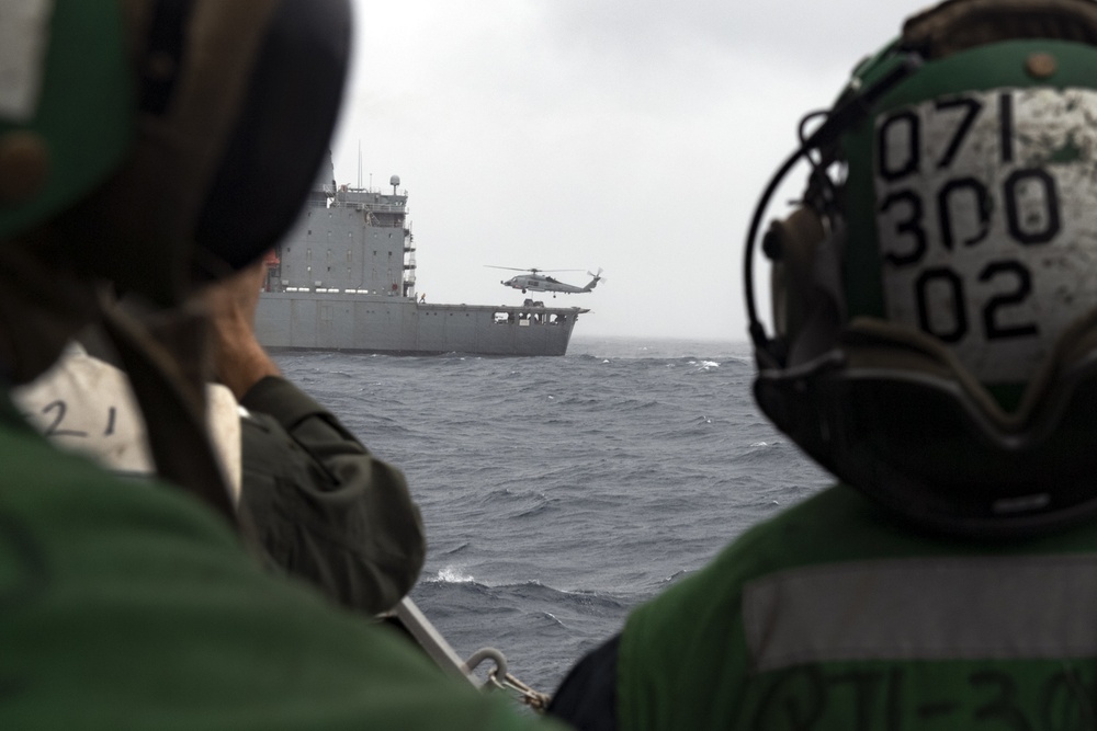 Sailors aboard USS Rafael Peralta (DDG 115) await a MH-60R Seahawk assigned to (HSM-51) during a vertical replenishment with USNS Pecos (T-AO-197)