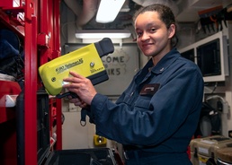 Damage Controlman 3rd Class Lareesa Garza, from Fayetteville, N.C., inspects a Naval Firefighter Thermal Imager (NFFTI) during routine maintenance