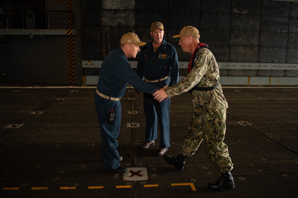 Rear Adm. Christopher Engdahl, commander, Expeditionary Strike Group 7/Task Force 76 greets Capt. Brian Schrum, commanding officer of USS New Orleans