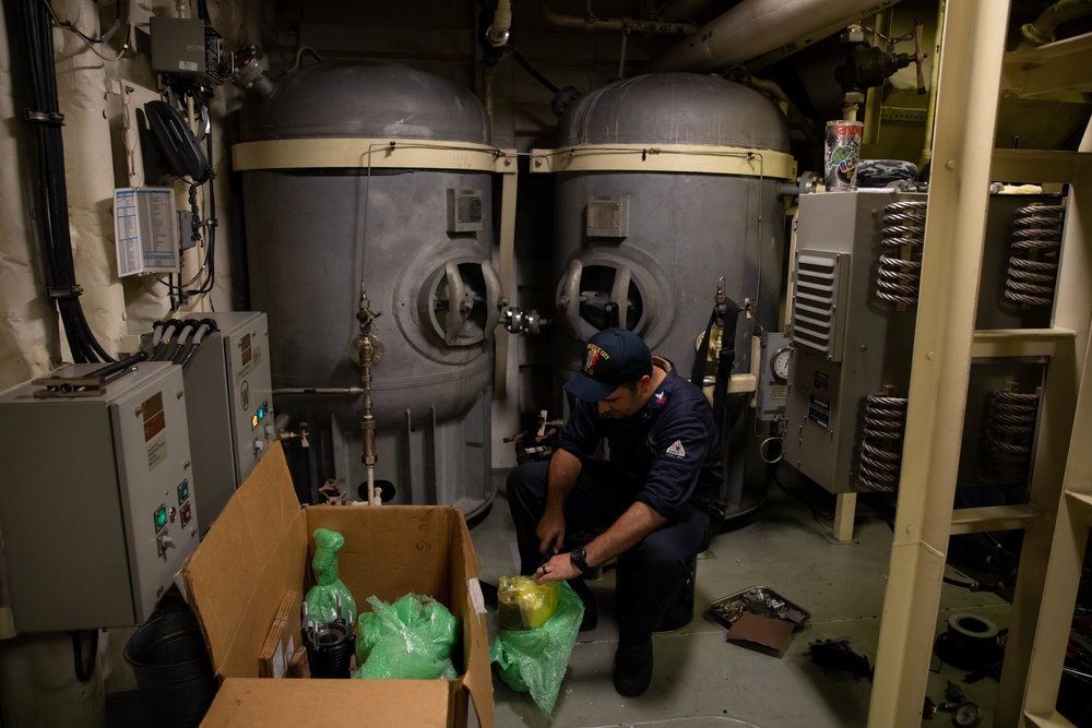 USS Sioux City Sailor Conducts Maintenance on Machinery While in Port