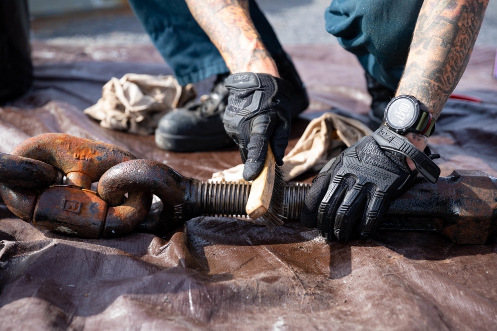 USS Sioux City Sailor Conducts Maintenance on Anchor Chain While in Port