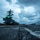 USS Ronald Reagan Conducts Flight Operations in the South China Sea A low-angle photograph taken on the flight deck of a large aircraft carrier, likely a US Navy supercarrier, captured during overcast/dusk conditions. The island superstructure dominates the left-center of the frame, with multiple aircraft and deck personnel visible across the flight deck. The wet deck surface and dramatic storm clouds create a moody, atmospheric composition.