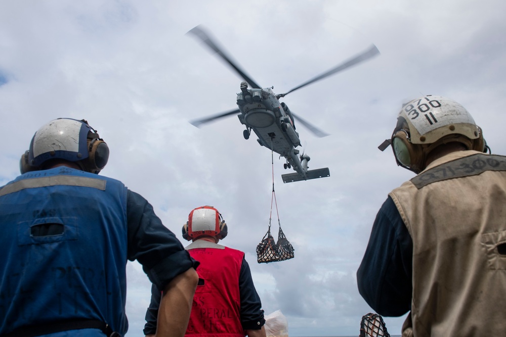 Sailors await stores deliver from a MH-60R Seahawk assigned to the “Warlords” of Helicopter Maritime Strike Squadron (HSM-51)