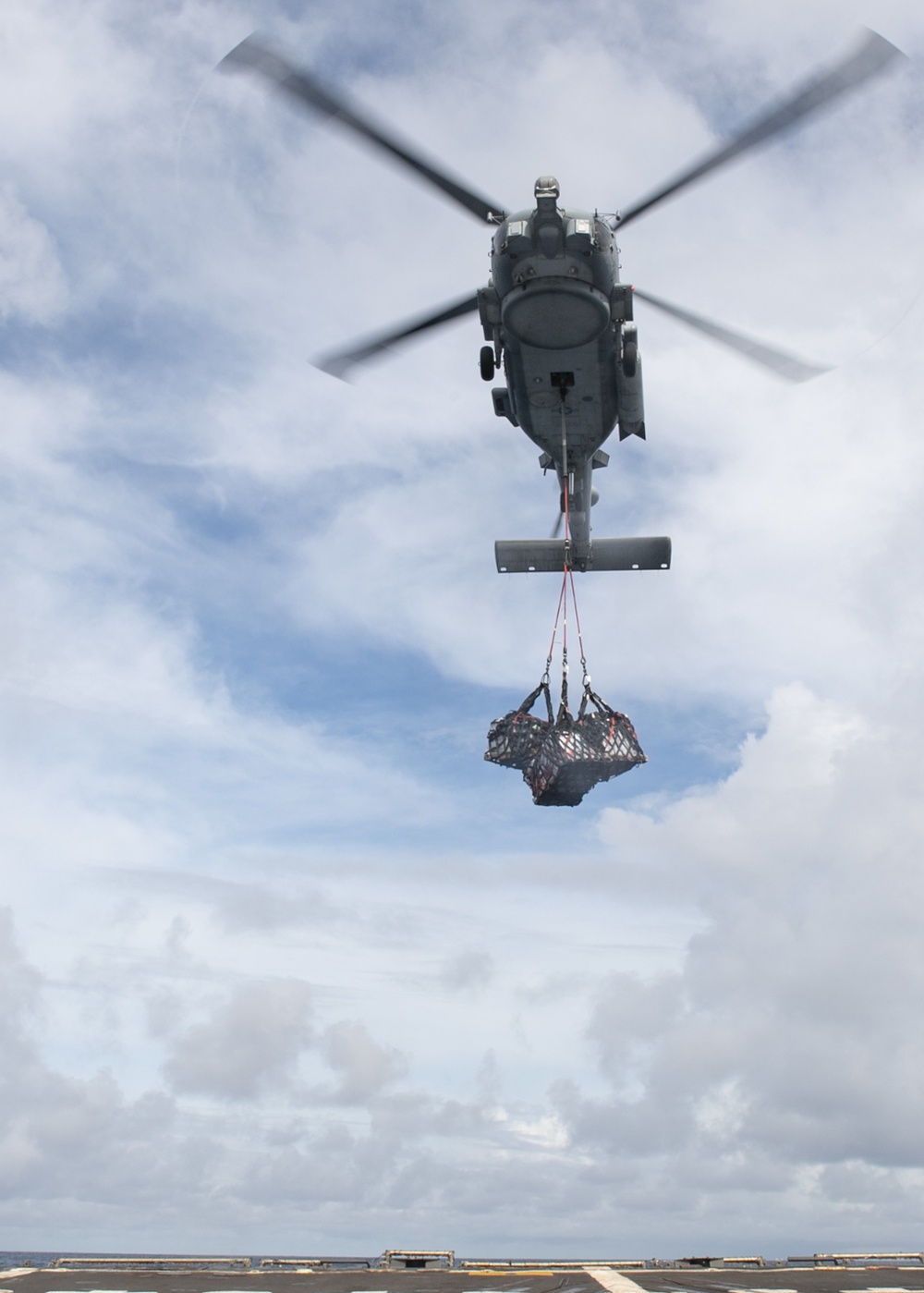 A MH-60R Seahawk assigned to the “Warlords” of Helicopter Maritime Strike Squadron (HSM-51) prepares to deliver stores