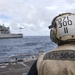 A Sailor awaits a MH-60R Seahawk assigned to the “Warlords” of Helicopter Maritime Strike Squadron (HSM-51)