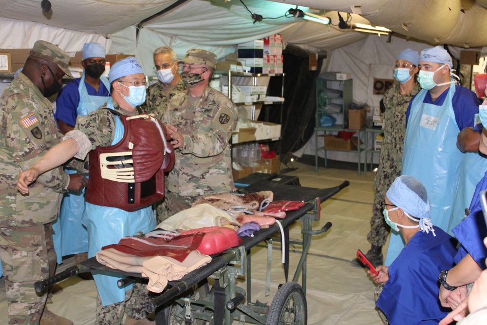 Soldiers and Sailors work with a &quot;cut suit&quot; during Global Medic