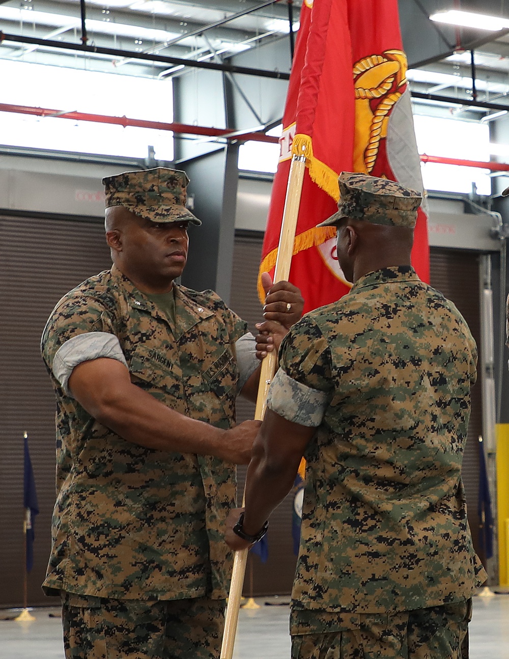 Lt. Col. Kurtis Sargent, left, incoming commanding officer, 2d Force Storage Battalion, Marine Force Storage Command, accepts 2d MFSB’s colors from Lt. Col. Fred Glencamp, outgoing CO, 2d FSB