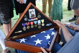 Famly members view U.S. Flag and decorations of Cpl. Eldert J. Beek