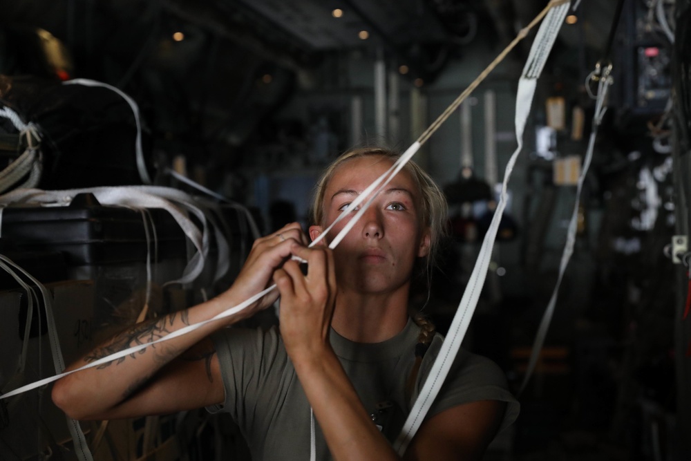 Army rigger checks the static line for pallet set for air drop