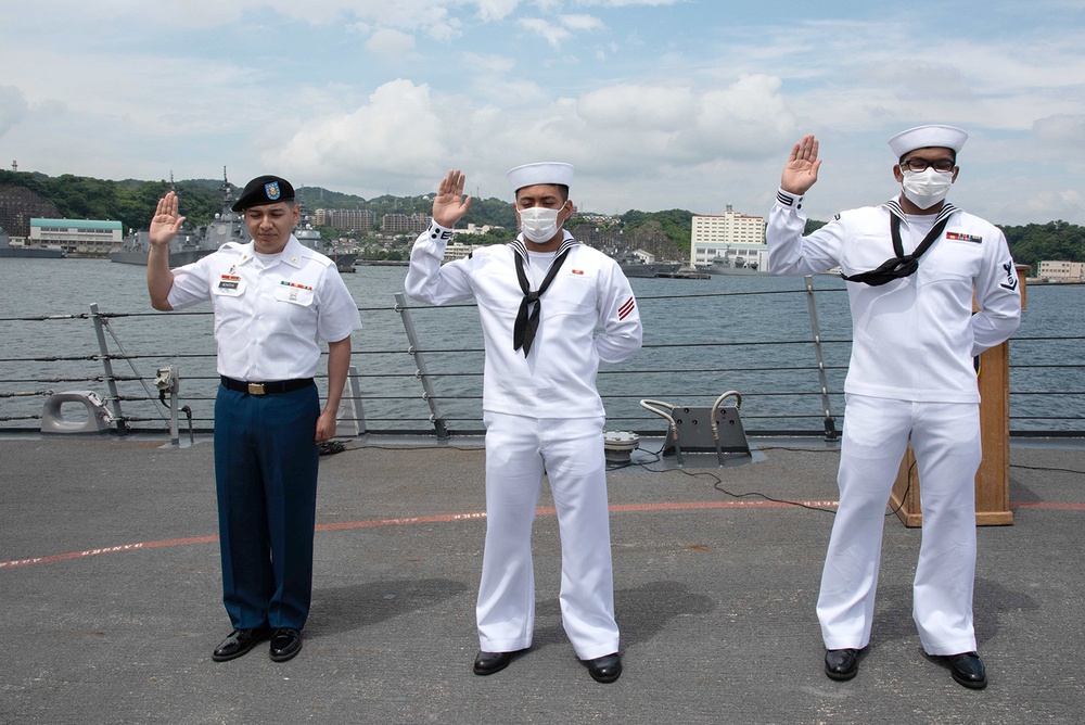 Two Sailors and one Soldier become new citizens of the U.S. during a naturalization ceremony aboard USS Milius stationed at CFAY
