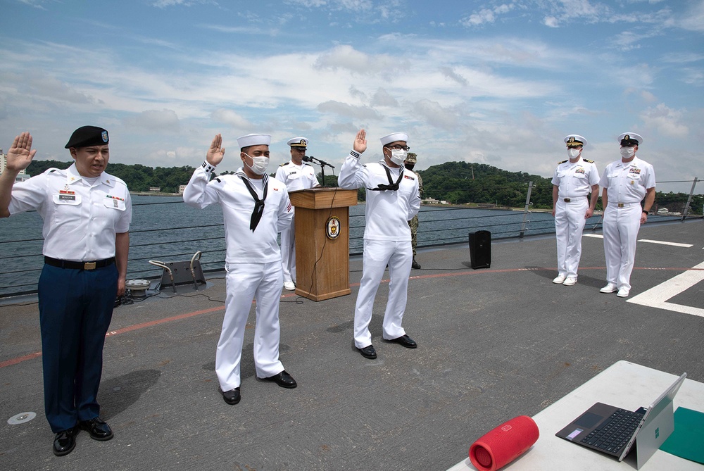 Two Sailors and one Soldier become new citizens of the U.S. during a naturalization ceremony aboard USS Milius stationed at CFAY
