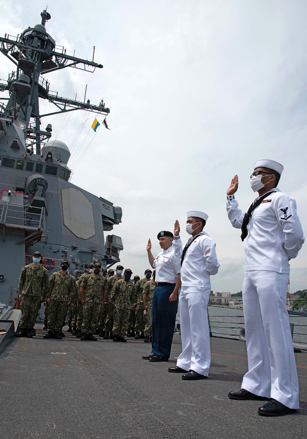 Two Sailors and one Soldier become new citizens of the U.S. during a naturalization ceremony aboard USS Milius stationed at CFAY
