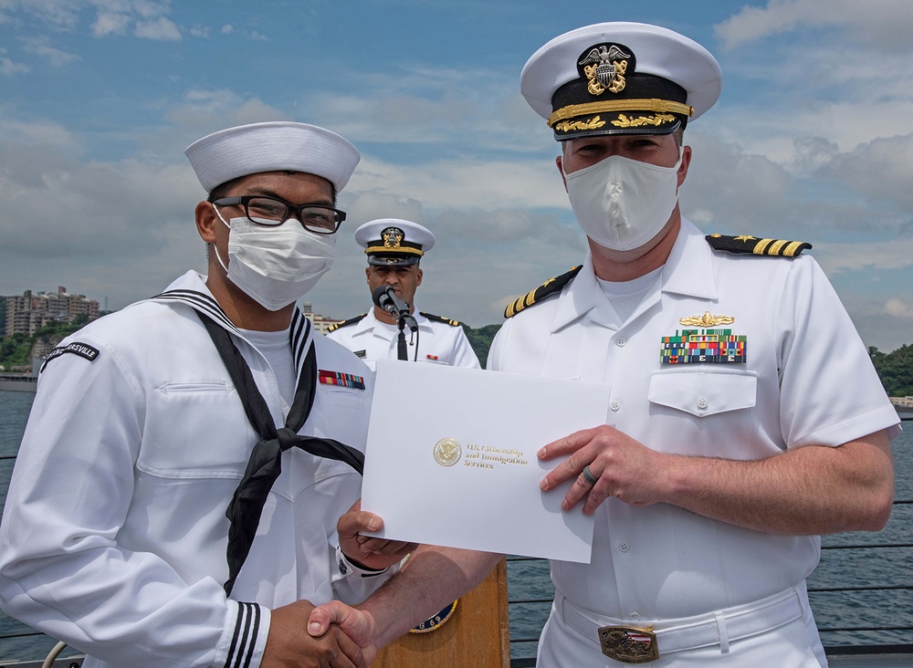 Two Sailors and one Soldier become new citizens of the U.S. during a naturalization ceremony aboard USS Milius stationed at CFAY