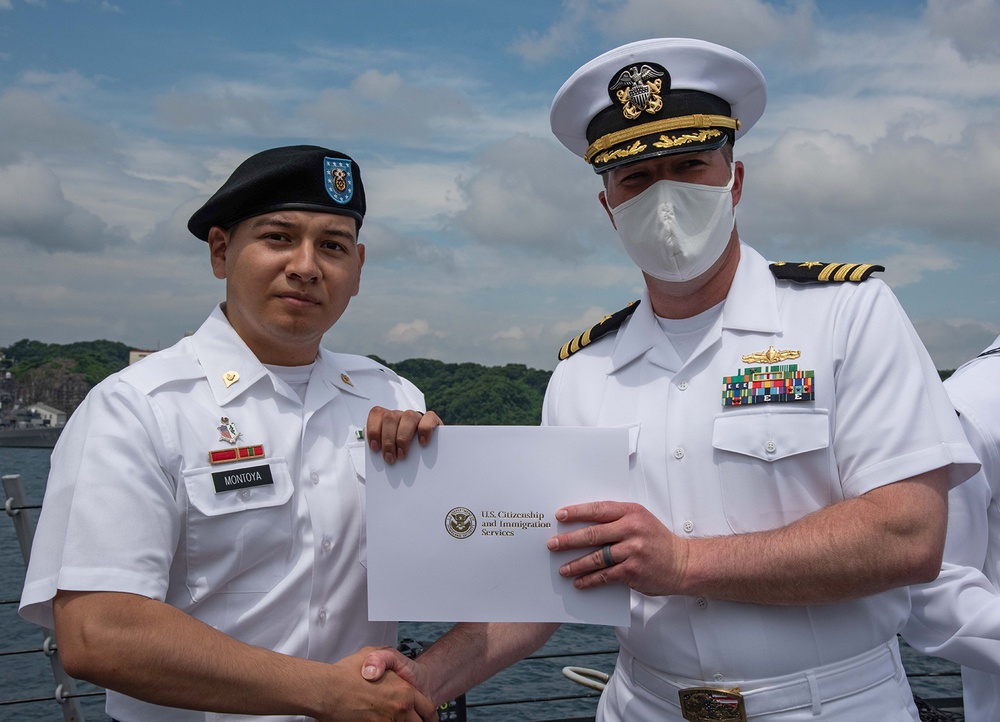 Two Sailors and one Soldier become new citizens of the U.S. during a naturalization ceremony aboard USS Milius stationed at CFAY