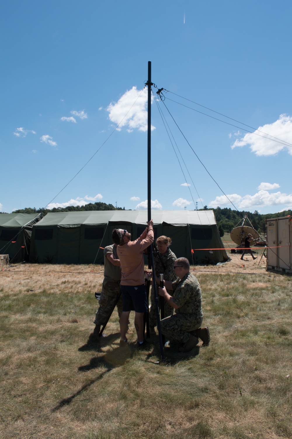 Sailors and Airmen assemble a ham radio HF antenna for Patriot 21