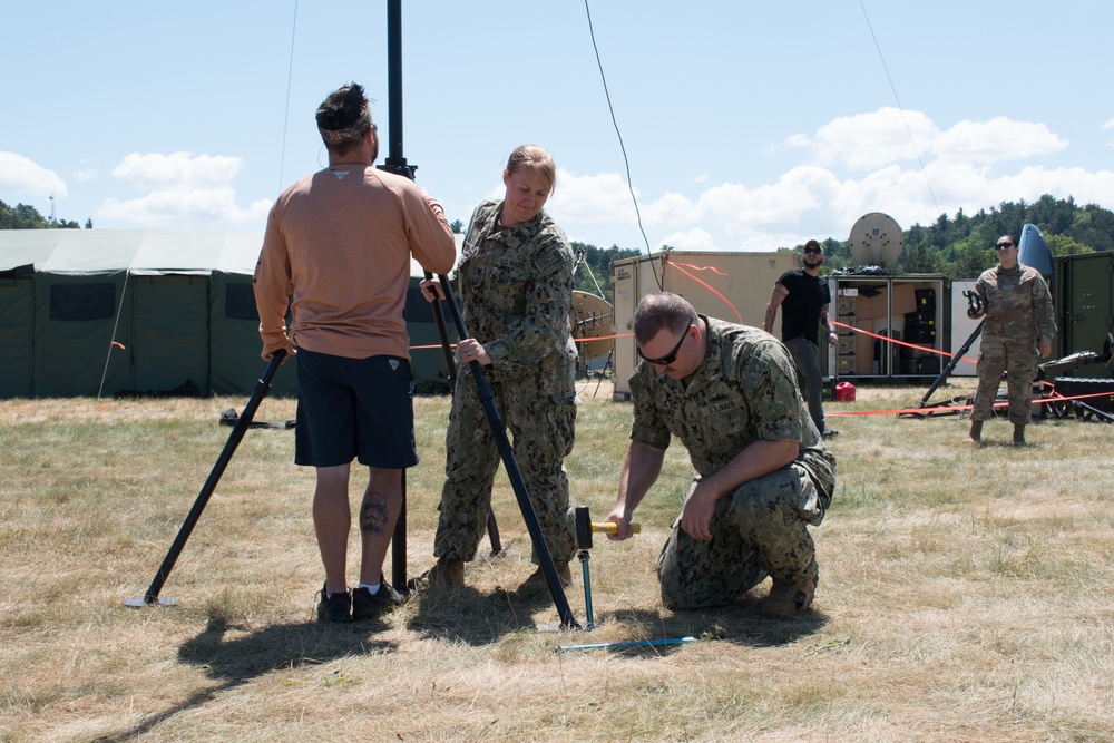 Sailors and Airmen assemble a ham radio HF antenna for Patriot 21