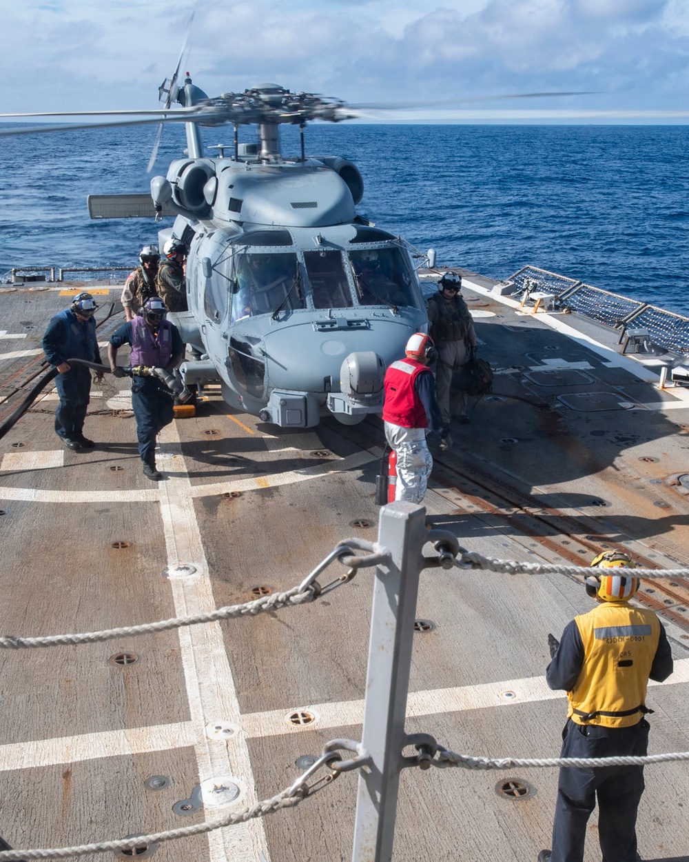 Sailors prepare to refuel a MH-60R Seahawk assigned to the “Warlords” of Helicopter Maritime Strike Squadron (HSM-51)