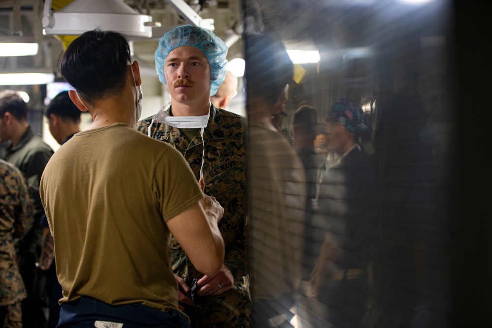 US Navy Sailors conduct a simulated mass casualty drill in response to a helicopter raid training exercise