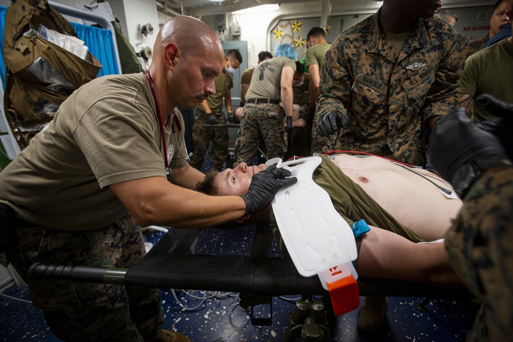 US Navy Sailors conduct a simulated mass casualty drill in response to a helicopter raid training exercise