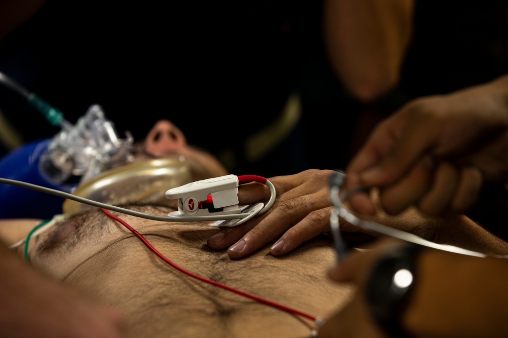 US Navy Sailors conduct a simulated mass casualty drill in response to a helicopter raid training exercise