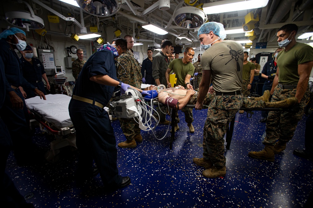 US Navy Sailors conduct a simulated mass casualty drill in response to a helicopter raid training exercise