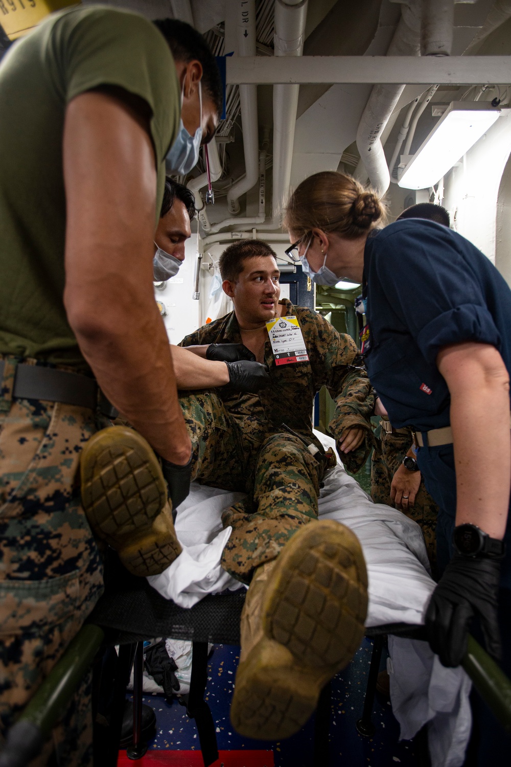 US Navy Sailors conduct a simulated mass casualty drill in response to a helicopter raid training exercise