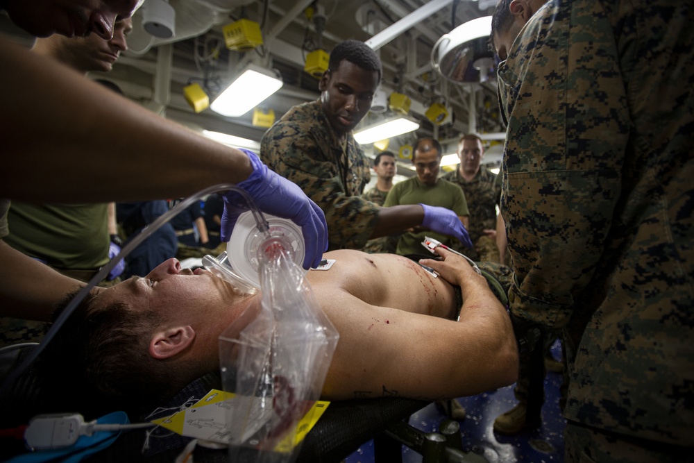 US Navy Sailors conduct a simulated mass casualty drill in response to a helicopter raid training exercise