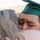 Idaho Youth Challenge Graduates 15th Class A graduate wearing a green mortarboard cap with a gold tassel marked '2021' is embracing another person in an emotional hug. The graduate appears to be crying or deeply moved, with a visibly emotional facial expression. The scene captures an intimate, heartfelt moment from a 2021 graduation ceremony.