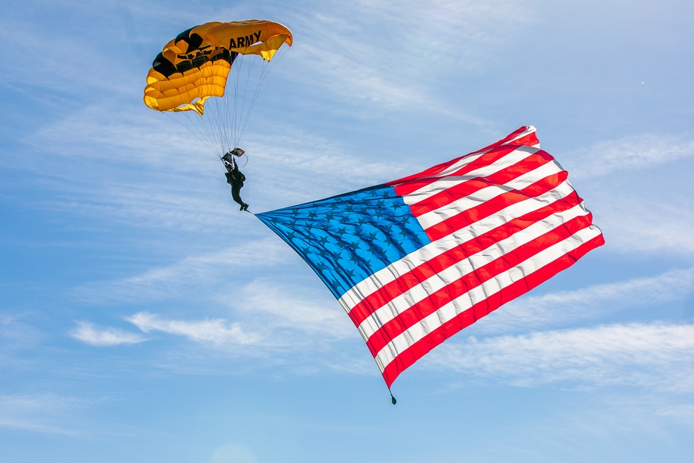 Parachutist on Army Golden Knights makes jump with flag banner