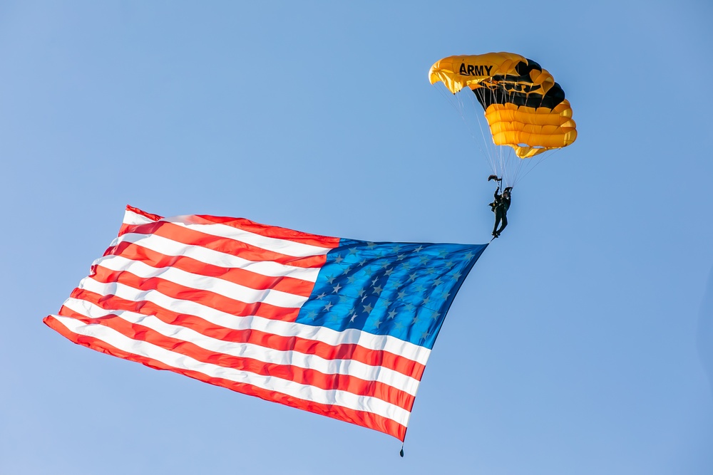 Parachutist on Army Golden Knights makes jump with flag banner