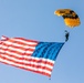 Parachutist on Army Golden Knights makes jump with flag banner