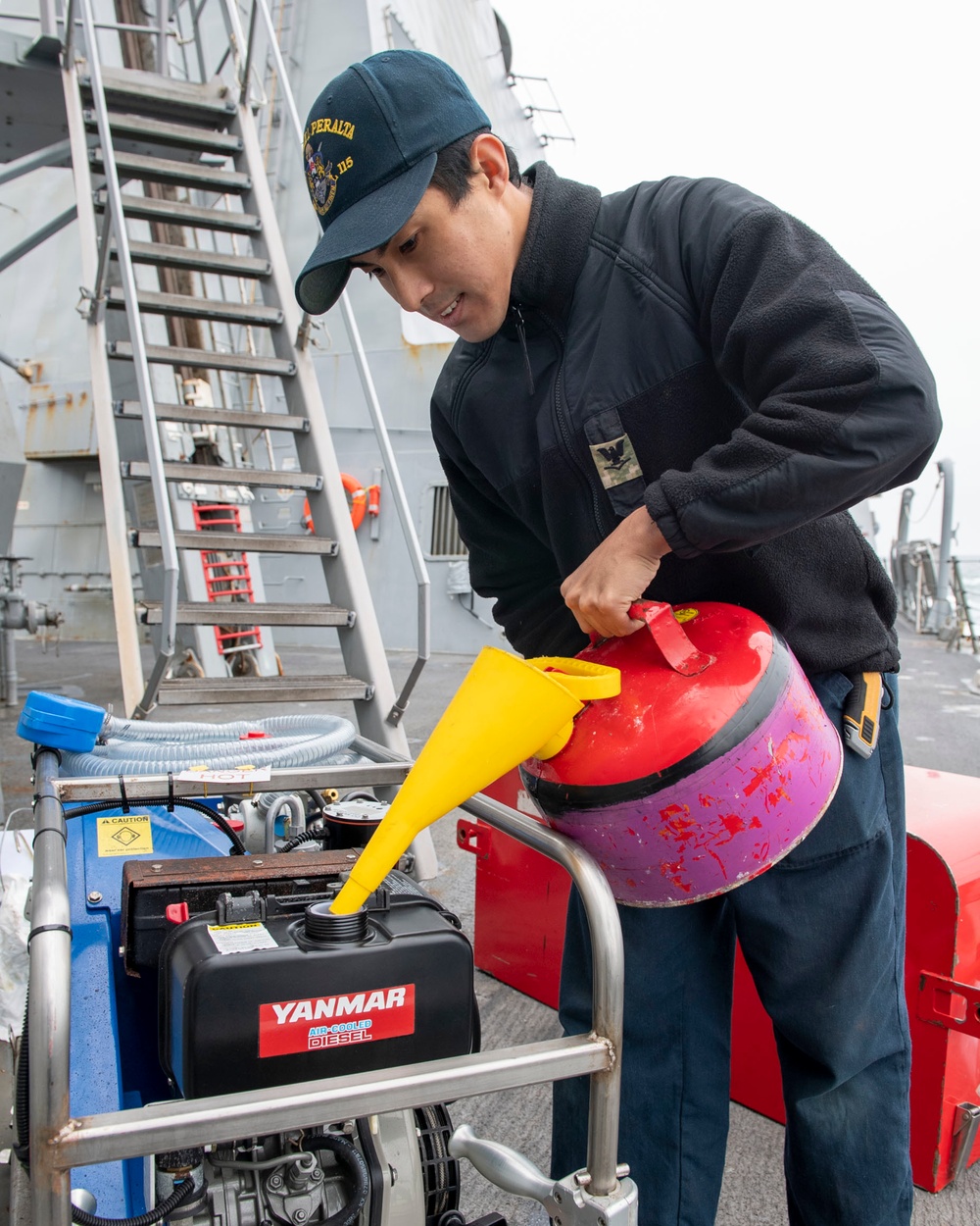 Damage Controlman 3rd Class Karl Bisuelan from Riverbank, Calif., refuels an emergency breathing apparatus compressor (EBAC)