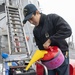 Damage Controlman 3rd Class Karl Bisuelan from Riverbank, Calif., refuels an emergency breathing apparatus compressor (EBAC)