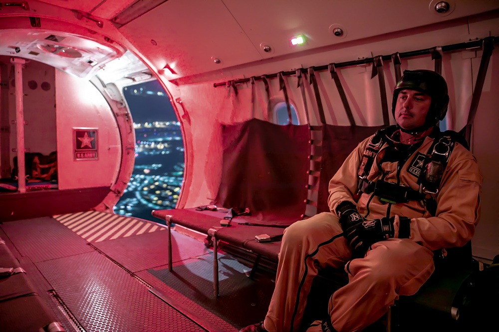 Parachutist on Army Golden Knights prepares to make night jump