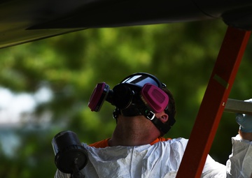 Airmen conduct maintenance on historical aircraft displays