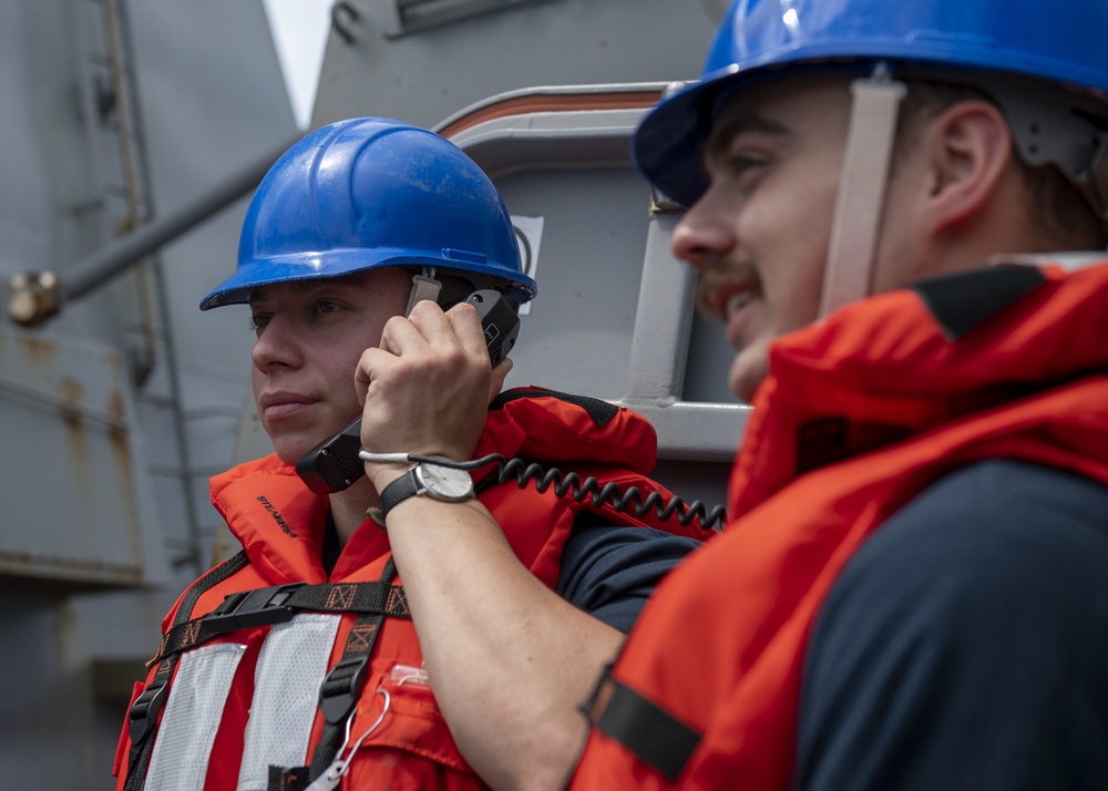 Information Systems Technician 2nd Class Isaak Mejia (left), from Los Angeles, Calif., communicates with the pilot house