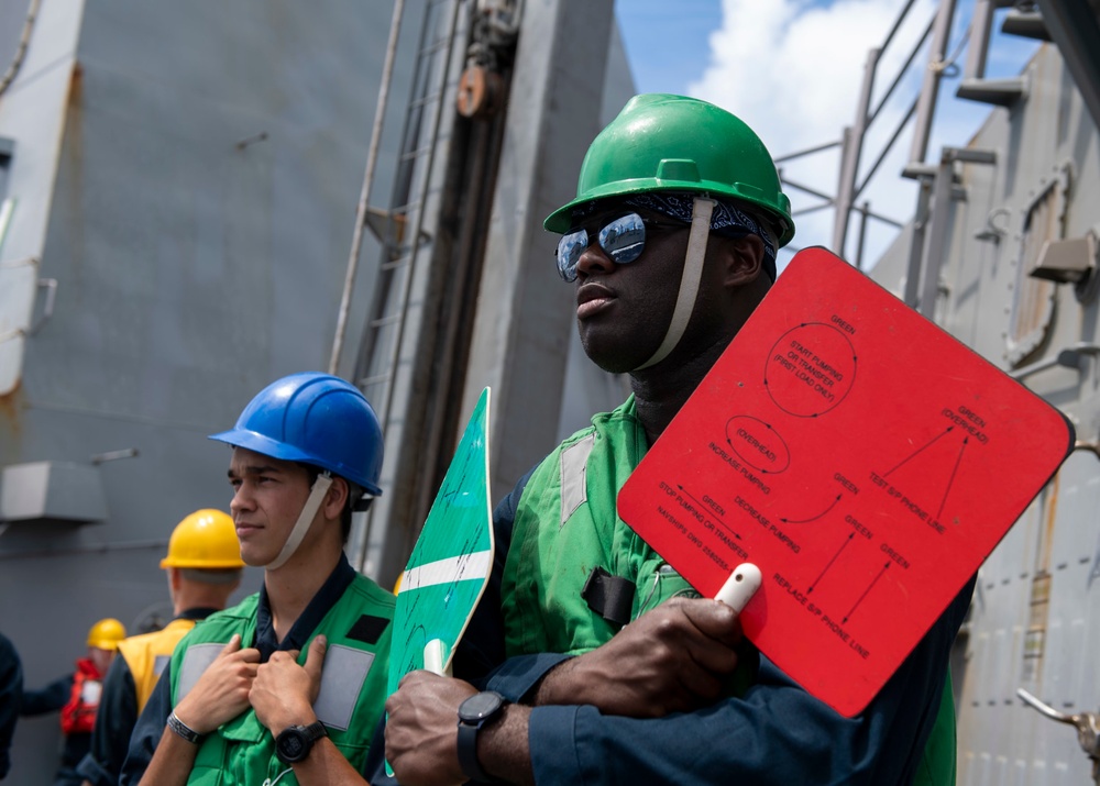Seaman Isiah Jackson (left), from San Diego, Calif., and Seaman Jonathan Taylor (right), from Killeen, Texas, signals the USNS Amelia Earhart