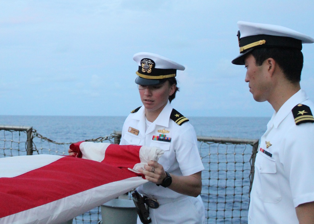 Sailors fold an American flag following a remembrance ceremony for the Solomon Islands campaign