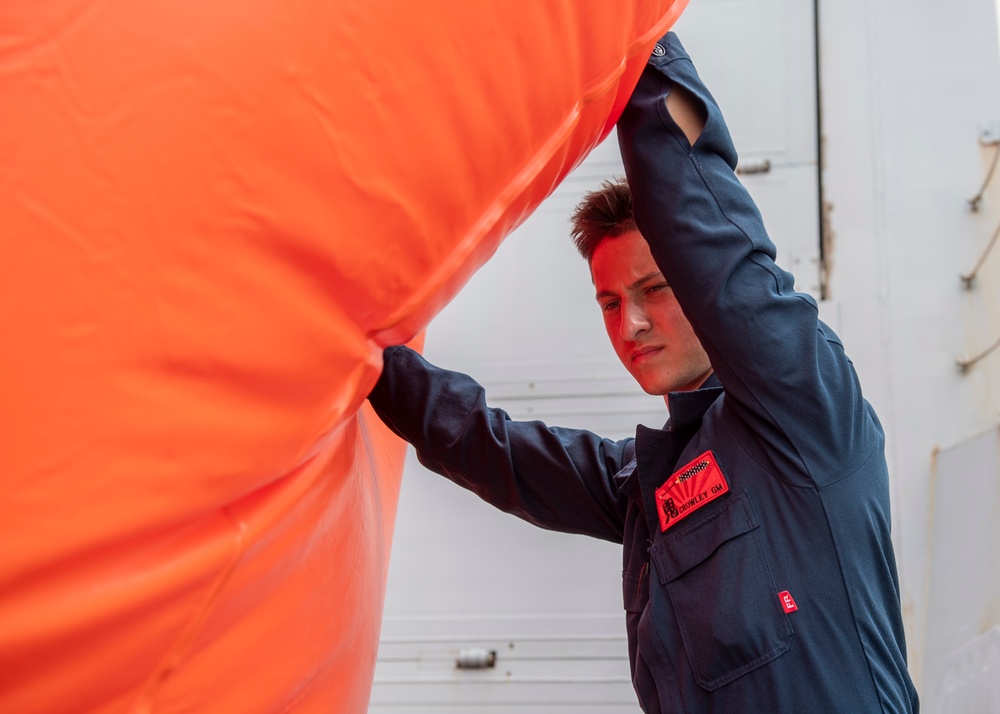 Gunner’s Mate Seaman Aidan Crowley, from Salt Lake City, Utah, inflates a floating target
