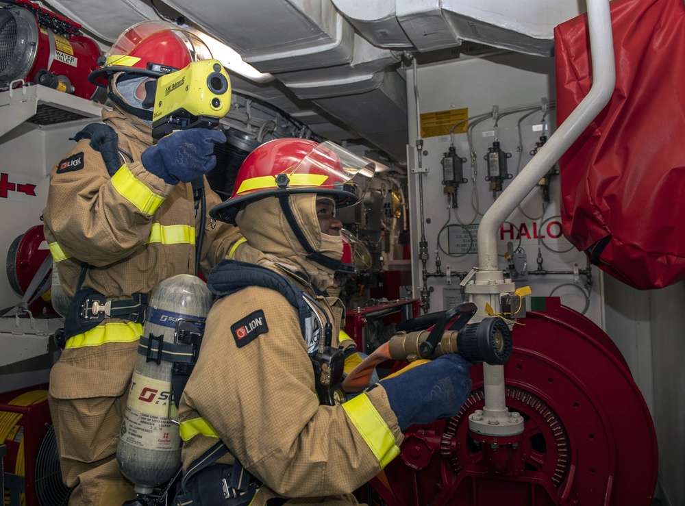 Sailors fight a simulated fire during a firefighting drill