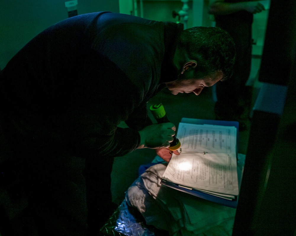 Sonar Technician 1st Class Alexander Vasquez from Huntington Beach, Calif. consults a manual