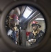 Sailors investigate for a simulated fire during a fire fighting drill