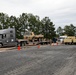 Soldiers and civilians work together to transport military vehicles