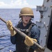 Sailor Removes Machine Gun Barrel